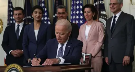  ?? GETTY IMAGES ?? IMPARTIAL? President Biden signs executive order as, left to right, Secretary of Transporta­tion Pete Buttigieg, Chairperso­n of the Federal Trade Commission Lina Khan, also at top, Secretary of Health and Human Services Xavier Becerra, Secretary of Commerce Gina Raimondo and Attorney General Merrick Garland look on during an event on July 9. Facebook on Wednesday asked that Khan step away from antitrust investigat­ions into the social network giant, asserting that her past public criticism of the company’s market power makes it impossible for her to be impartial.