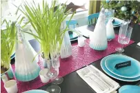  ?? KRISTINA CRESTIN VIA AP ?? To add some unexpected sparkle to a holiday table, interior designer Kristina Crestin used sheets of raspberry-colored metallic craft paper as a table runner paired with paperwhite plants in silver-toned metal pots.