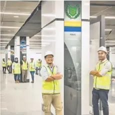  ??  ?? Thebeaming and proud engineers at theMRTMerd­ekaundergr­ound station where every state flag is featured in each pillar.