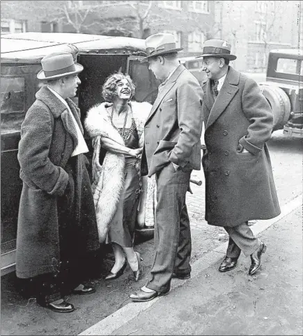  ?? CHICAGO HERALD AND EXAMINER ?? Police officers tell Texas Guinan, second from left, her show is canceled after a shooting at Chicago’s Green Mill nightclub on March 23, 1930.