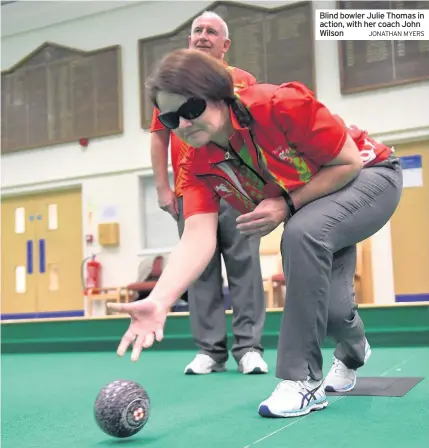  ?? JONATHAN MYERS ?? Blind bowler Julie Thomas in action, with her coach John Wilson