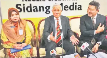  ??  ?? Manyin (centre), flanked by Rakayah and his ministry’s permanent secretary Datu Sudarsono Osman, shares a light moment with members of the media during the press conference.