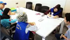  ??  ?? Enforcemen­t officers check details of a company and workers at Demak Laut Industrial area.