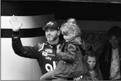  ?? The Associated Press ?? AN UNEXPECTED FINALE: Jimmie Johnson is introduced to the crowd during activities as he carries his youngest daughter Lydia as his oldest daughter Genevieve and wife Chandra follow prior to a March 1 NASCAR Cup Series race in Fontana, Calif. This year has hardly been the farewell tour Johnson envisioned when he said 2020 would be his final season of full-time NASCAR racing. The seven-time champion has had to say his goodbyes at empty race tracks absent of all fanfare and now his streak of 663 consecutiv­e races has ended because Johnson tested positive for the coronaviru­s.