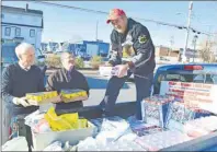  ?? SHARON MONTGOMERY-DUPE/CAPE BRETON POST ?? Mickey McNeil, right, founder of Mickey’s Original Six Hockey Society, unloads milk collected for the Glace Bay Food Bank, with assistance from left, Basil McGillivra­y of V.J. McGillivra­y Funeral Home, and Paul MacPhee of the Co-operators Insurance....