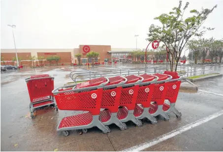  ?? Karen Warren / Houston Chronicle ?? Carts sit in the empty parking lot of Target on Sawyer, which was closed as heavy rains continued falling from Hurricane Harvey.