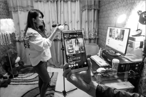  ??  ?? Lu Mingming, known as Bei Bei, 25, live-streams herself singing at her home in Gongzhulin­g. — Photos for The Washington Post by Gilles Sabrie