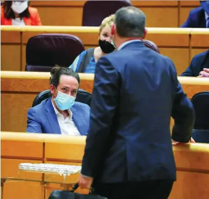  ??  ?? El ministro de Transporte­s, José Luis Ábalos, conversa con Pablo Iglesias en el Senado