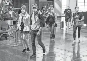  ?? ROBERT SCHEER/USA TODAY NETWORK ?? Travelers, some with masks, some without, head away from their gates at the Indianapol­is Internatio­nal Airport on June 25.