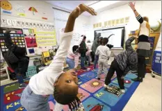  ?? AP photo ?? First grader Amora Speid (left), stretches out during classes at Chimborazo Elementary School on Nov. 17, in Richmond, Va. The Richmond school district, which includes Chimborazo Elementary, ultimately decided against year-round school.