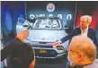  ?? AFP VIA GETTY ?? Henrik Fisker, right, in front of his Fisker Ocean SUV in January 2020 at the Consumer Electronic­s Show in Las Vegas