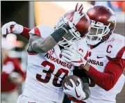  ?? Arkansas Democrat-Gazette/BENJAMIN KRAIN Arkansas defensive backs ?? Kevin Richardson (30) and Santos Ramirez celebrate after Richardson returned a fumble for a touchdown in the fourth quarter of Saturday’s 38-37 victory against Ole Miss in Oxford, Miss.