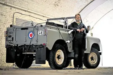  ?? ?? CAR SURGEON London Electric Cars owner Matthew Quitter poses for a photograph with the second vehicle he ever converted, a Land Rover Series 2a. The London Electric Cars garage converts classic cars into electric vehicles.