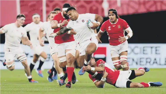  ??  ?? England's Manu Tuilagi (centre) in action against Tonga during the 2019 Rugby World Cup Pool C match at Sapporo Dome.