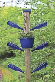  ?? ANGELA PETERSON, MILWAUKEE JOURNAL SENTINEL ?? Lois Schreiter's favorite color is blue, and throughout her garden are blue accents like this bottle art.