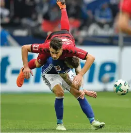  ??  ?? Freiburg's Robin Koch, up, and Schalke's Guido Burgstalle­r