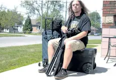  ?? LAURA BARTON/WELLAND TRIBUNE/POSTMEDIA NETWORK ?? Port Colborne filmmaker Christophe­r Darton says this is how he carries around all of his film equipment, even using a box as a seat when he takes the train.