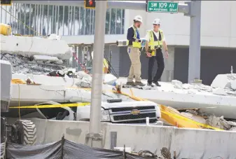  ?? C.M. Guerrero / Miami Herald ?? Inspectors examine the northern end of the collapsed pedestrian bridge at Florida Internatio­nal University in Miami on Sunday. Cracks were found before the bridge failed.