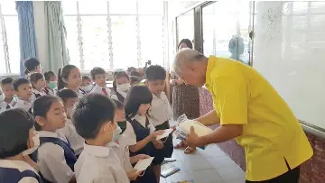  ??  ?? Ting distributi­ng face masks to pupils of SJK(C) Chung Hua Lutong.