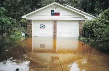  ?? LUKE SHARRETT/BLOOMBERG ?? Flood waters surround a home in The Woodlands community, north of Houston, last Tuesday. The estimated damage from Harvey ranges from US$42 billion to more than US$100 billion.