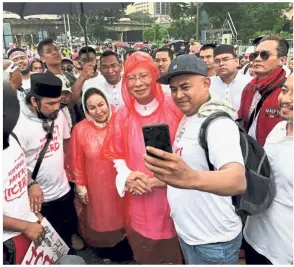  ??  ?? In the spotlight: Supporters taking a photo with Najib and Rosmah at the rally in Kuala Lumpur.