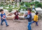 ?? AFP ?? Children play by graves in the Ghoraba cemetery in Lebanon’s northern port city of Tripoli, where multiple marginaliz­ed families reside.