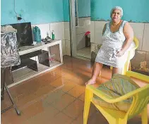  ??  ?? Silvana Francisca de Oliveira dentro de sua casa alagada: ‘água podre’