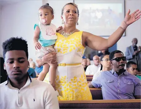  ?? Chip Somodevill­a Getty Images ?? WORSHIPERS pray at Mt. Zion First African Baptist Church in Charlottes­ville, Va., a day after violence at a “Unite the Right” rally.