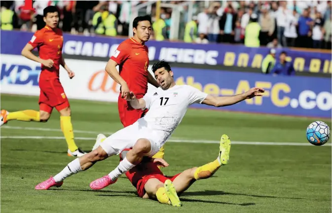  ??  ?? TEHRAN: Iran’s Mehdi Taremi (17) plays against China’s Zhang Linpeng during the 2018 World Cup qualifying football match between Iran and China at the Azadi Stadium in Tehran yesterday. — AFP