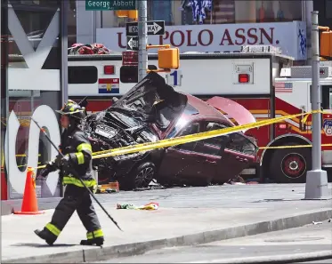  ?? Associated Press photo ?? A smashed car sits on the corner of Broadway and 45th Street in New York's Times Square after ploughing through a crowd of pedestrian­s at lunchtime on Thursday. Police do not suspect a link to terrorism and the driver was taken into custody to be...