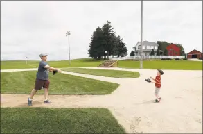  ?? Charlie Neibergall / Associated Press ?? Jeremiah Bronson, of Ames, Iowa, plays catch with his son Ben, right, on the field at the “Field of Dreams” movie site June 5 in Dyersville, Iowa.