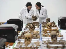  ?? — AFP ?? SEOUL: Members of South Korea’s Agency for KIA Recovery and Identifica­tion check the remains of Chinese soldiers, who fought during the Korean War, during ceremonial rites to place the remains at a temporary military ossuary. The remains of 28 Chinese...