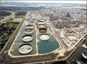  ?? The Dallas Morning News/TOM FOX ?? Rainwater from Hurricane Harvey fills the retention ponds built around storage tanks at Exxon Mobil’s refinery in Baytown, Texas.