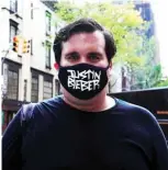  ??  ?? A man wears face mask with a Justin Bieber graphic during the coronaviru­s pandemic in New York City.