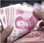  ??  ?? File photo of a bank clerk counting Chinese yuan banknotes at an Industrial and Commercial Bank of China branch in Huaibei, China. — Reuters