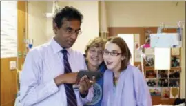  ?? THE UNIVERSITY OF CHICAGO MEDICINE VIA AP ?? Heart transplant surgeon Valluvan Jeevananda­m, MD, chief of cardiac surgery at the University of Chicago Medicine, shows triple transplant patient Sarah McPharlin, right, photos on his phone in Chicago. University of Chicago Medicine doctors announced Friday that they successful­ly completed the triple organ transplant­s on Sarah McPharlin, a 29-year-old woman of Grosse Pointe Woods, Michigan, and Daru Smith, a 29-yearold father from Chicago’s South Side, within 30 hours of one another.