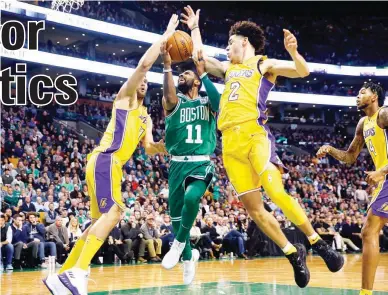  ??  ?? Boston Celtics guard Kyrie Irving (11) goes between Los Angeles Lakers' Lonzo Ball (2) and Brook Lopez during the fourth quarter of Boston's 107-96 win in the NBA in Boston Wednesday. (AP)