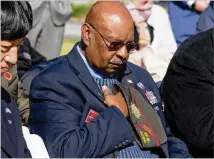  ??  ?? Charles A. Dobbins lowers his head throughout the invocation during the Veterans Day observance on Sunday. Ten million combatants representi­ng 32 nations died during “the Great War.”