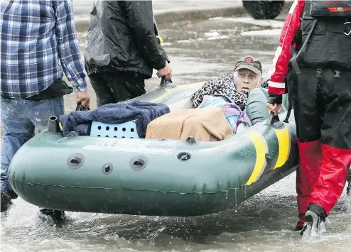  ?? SCOTT OLSON / GETTY IMAGES ?? Rescue workers and volunteers help residents make their way out of a flooded neighbourh­ood in Houston.