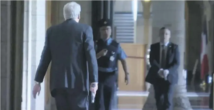  ?? THE CANADIAN PRESS FILES ?? Kevin Vickers, left, then the sergeant-at-arms of the House of Commons, is seen in Parliament’s Hall of Honour carrying a gun in this still image from Oct. 22, 2014.