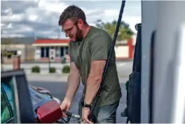  ?? STAFF PHOTO ?? Ben Michaels pumps gas into his car at the Speedway gas station in 2021 on the corner of S. Holtzclaw Avenue and E. Third Street.