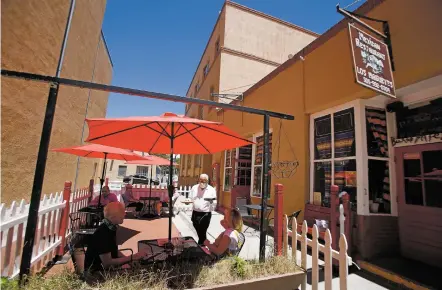  ?? PHOTOS BY LUIS SÁNCHEZ SATURNO/THE NEW MEXICAN ?? Enrique Zanrano brings out an order for Michael Iglinski and his wife, Peggy Iglinski, who were passing through from Las Vegas, Nev., on Wednesday at Los Magueyes Mexican Restaurant. Eateries statewide are allowed to open for more than takeout, with outdoor seating limited to 50 percent of capacity.