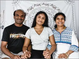  ?? NATRICE MILLER/NATRICE.MILLER@AJC.COM ?? Lakshmi Potturu, 17, sits with her mother and father in her Johns Creek bedroom this month. Although she moved to the U.S. with her family when she was 2, her legal status is based upon her father’s temporary work visa.