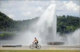  ?? Lucy Schaly/Post-Gazette ?? A bicyclist rides past the fountain at Point State Park on Wednesday, the first official day that the fountain is up and running for the summer. “The fountain is a symbol of returning to normalcy,” park manager Jacob Weiland said. Story, Page B-2.