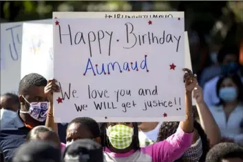  ?? John Bazemore/Associated Press ?? A woman holds a sign at a rally Friday in Brunswick, Ga., protesting the death of Ahmaud Arbery, an unarmed black man. Two men were arrested Thursday in connection with his February death.