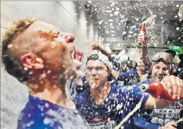  ?? Wally Skalij Los Angeles Times ?? DODGERS’ JOC PEDERSON, second from left, celebrates with teammates after defeating the Colorado Rockies to win the National League West at Dodger Stadium on Monday.