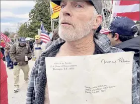  ?? Matthew Rosenberg / The New York Times ?? Barnett shows off the envelope he took from Pelosi’s office on Wednesday and bragged about it.