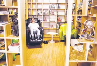  ?? Amy Osborne / Special to The Chronicle ?? Matt Marceau takes a break in the massage chair at the Eco-Systm co-working center, which lists its property on LiquidSpac­e, a self-styled Airbnb for office space.