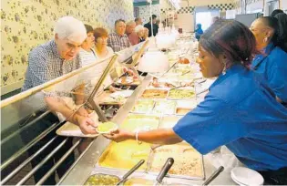  ?? JOE BURBANK/ORLANDO SENTINEL 2005 ?? Glenn Bebout, who had been coming to the same location since 1968, is served by Monica Duval at the Piccadilly cafeteria on East Colonial Drive during lunch on one of his last days at the restaurant. It closed in 2005.