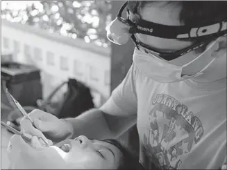  ?? Courtesy, Kindness in Action ?? Kevin Lobay performs dental work on a patient in Cambodia during a recent trip to help those in poverty.